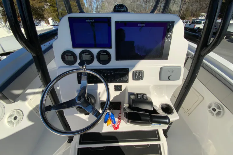 Slide: The Image of 2020 Aquasport 2500 Center Console helm with steering wheel and navigation displays. - 12