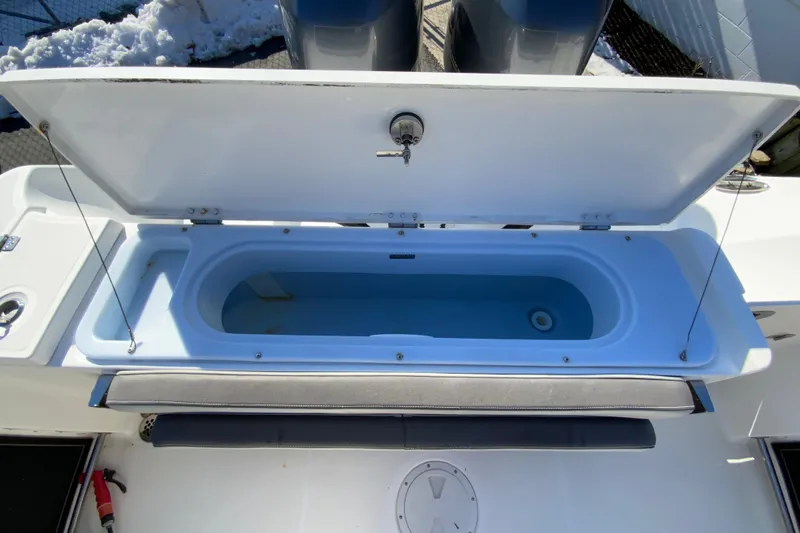 Slide: The Image of 2020 Aquasport 2500 Center Console livewell with open lid, showcasing spacious interior. - 16