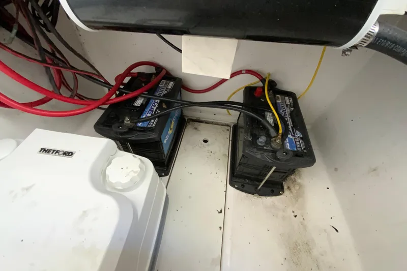 Slide: The Image of 2020 Aquasport 2500 Center Console boat battery compartment with wiring and Thetford component. - 28