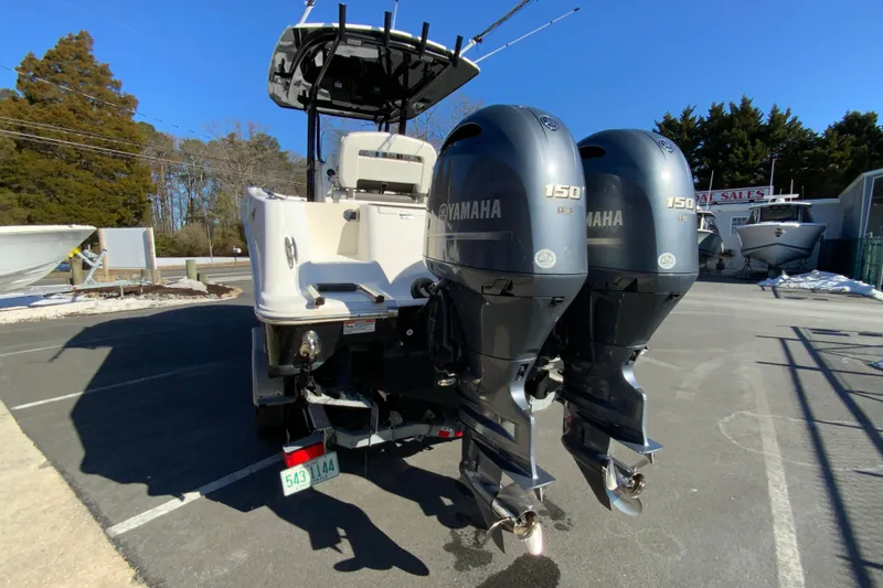 Slide: The Image of 2020 Aquasport 2500 Center Console with dual Yamaha 150 engines in a boatyard. - 8