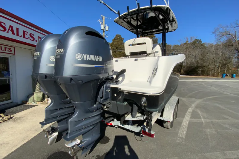 Slide: The Image of 2020 Aquasport 2500 Center Console with twin Yamaha engines, parked outdoors. - 9