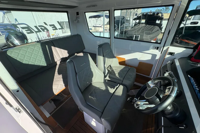 Slide: The Image of 2021 Axopar 28 Cabin interior with modern seating and steering wheel. - 10