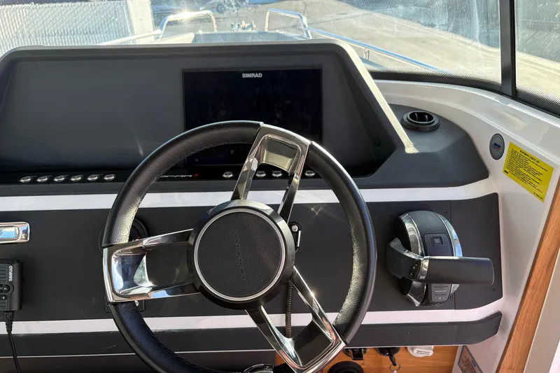 Slide: The Image of Steering wheel and controls of 2021 Axopar 28 Cabin boat cockpit. - 12