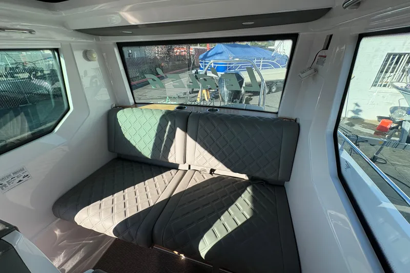 Slide: The Image of Interior of 2021 Axopar 28 Cabin boat with quilted seating and large windows. - 13