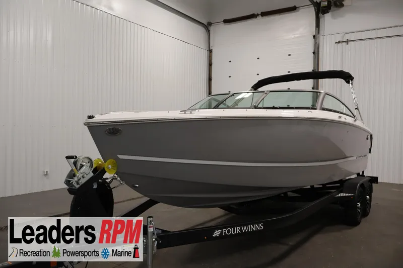 The Image of 2026 Four Winns H4 Freedom boat on trailer in indoor showroom. - 0