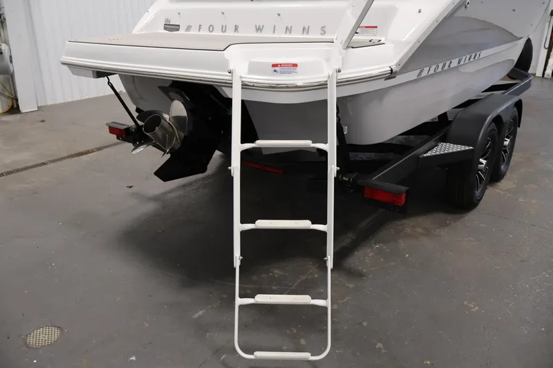 Slide: The Image of 2026 Four Winns H4 Freedom boat with ladder and trailer in a garage. - 35