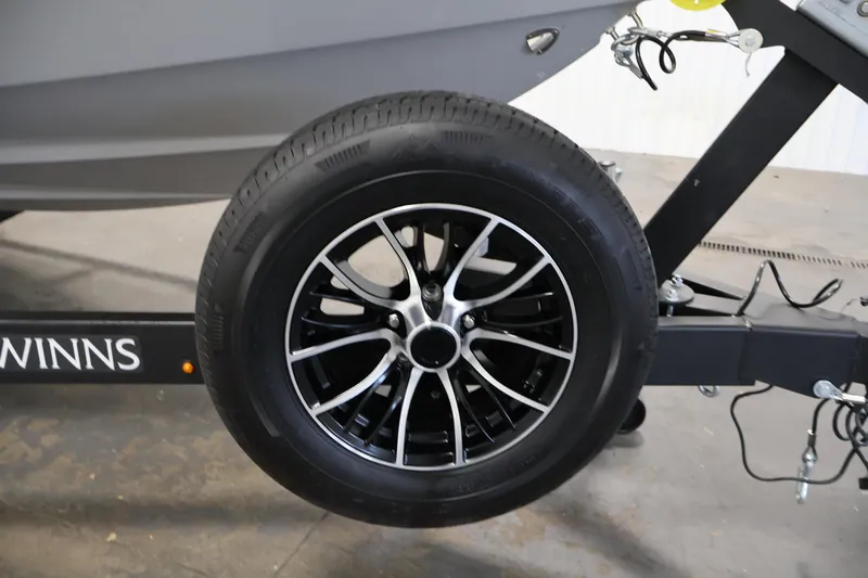 Slide: The Image of Trailer wheel of 2026 Four Winns H4 Freedom boat, featuring sleek black alloy rims. - 39