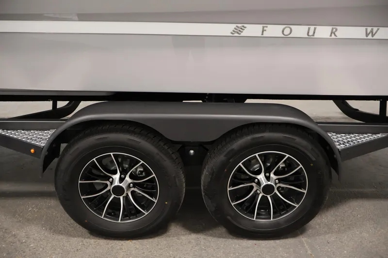 Slide: The Image of Trailer wheels of 2026 Four Winns H4 Freedom boat, featuring sleek black rims. - 41