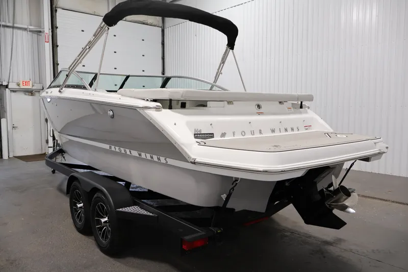 Slide: The Image of 2026 Four Winns H4 Freedom boat on trailer in indoor storage. - 6