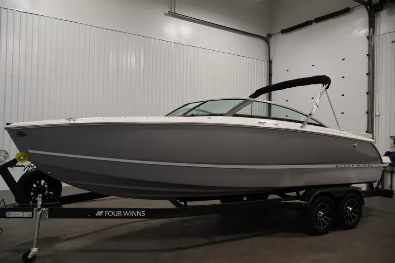Slide: The Image of 2026 Four Winns H4 Freedom boat on trailer in indoor showroom. - 7
