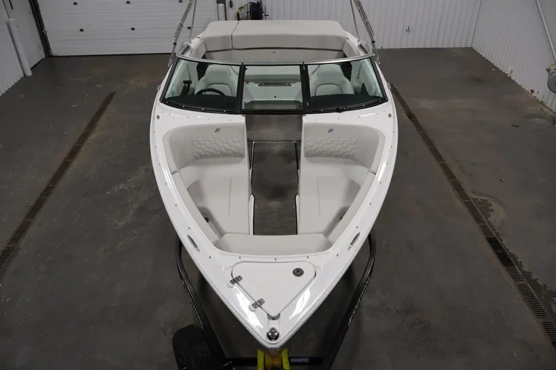 Slide: The Image of 2026 Four Winns H4 Freedom boat in a garage, showcasing sleek design and spacious seating. - 8
