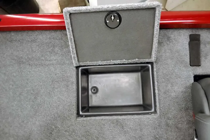 Slide: The Image of 2026 Ranger RT188 boat storage compartment with open lid on carpeted deck. - 24