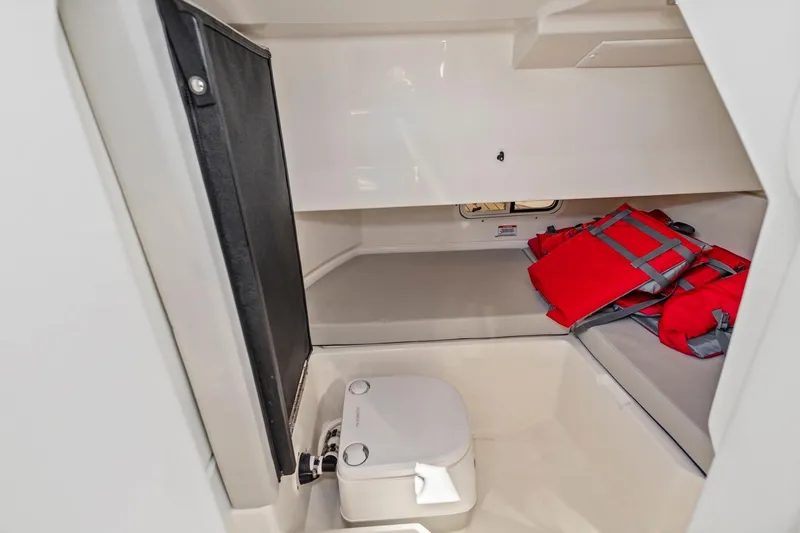 Slide: The Image of 2023 Sea Ray SDX 250 Outboard cabin interior with toilet and life jackets. - 15