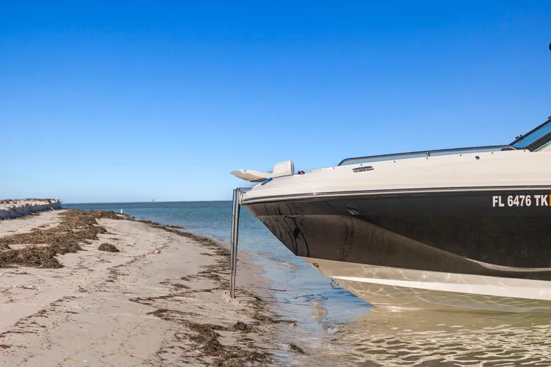 Slide: The Image of 2023 Sea Ray SDX 250 Outboard boat anchored on sandy beach, clear blue sky. - 6