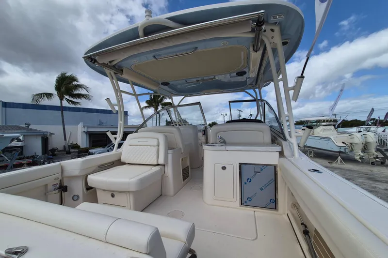 Slide: The Image of 2026 Grady-White Freedom 307 boat interior with seating and helm, under a blue sky. - 15