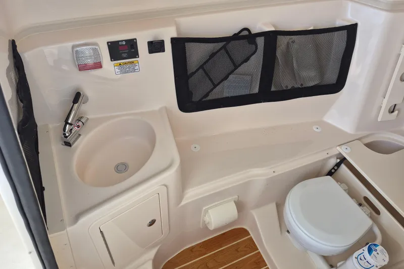 Slide: The Image of 2026 Grady-White Freedom 307 boat interior with sink and toilet amenities. - 21