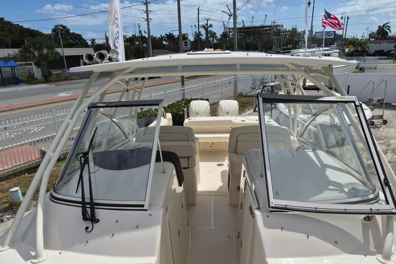 Slide: The Image of 2026 Grady-White Freedom 307 boat, dual console, outdoor display, American flag in background. - 24