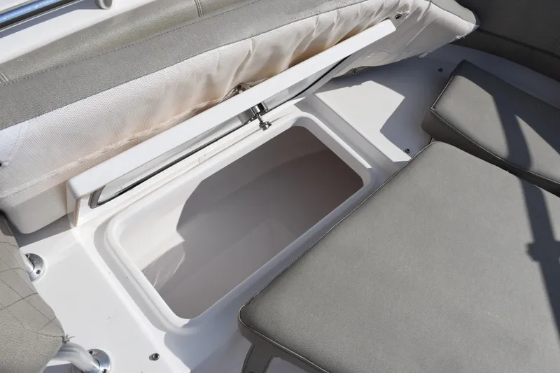 Slide: The Image of 2021 Sportsman Heritage 241 Center Console boat storage compartment with cushioned seating. - 18