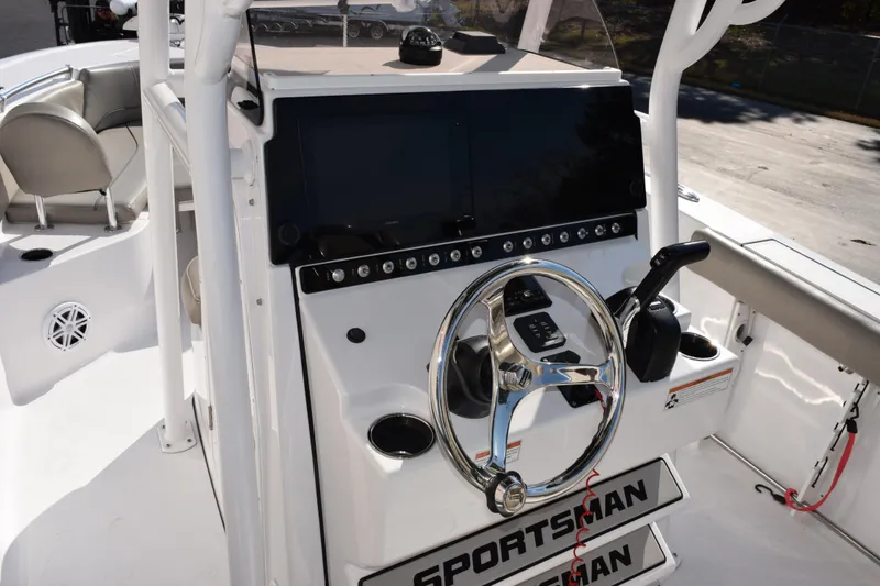 Slide: The Image of 2021 Sportsman Heritage 241 Center Console boat dashboard with steering wheel and controls. - 9