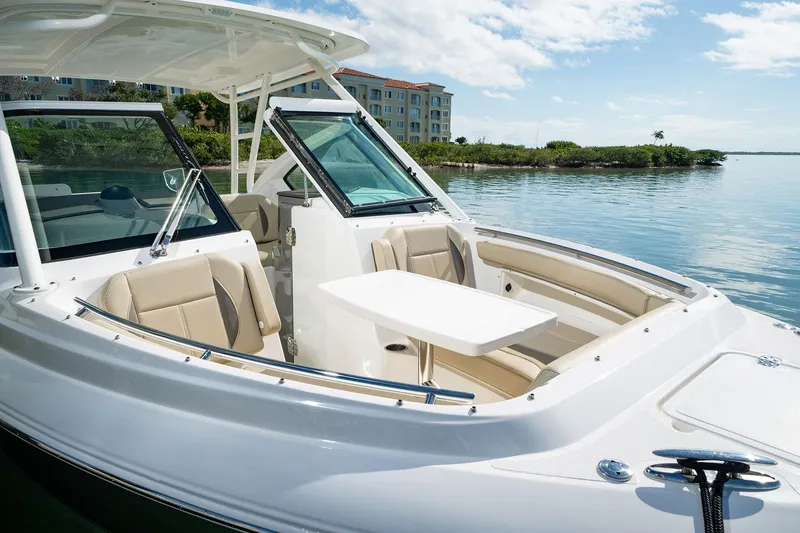Slide: The Image of 2026 Pursuit DC 266 Dual Console boat with seating and table on calm water. - 12
