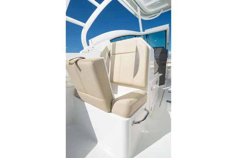 Slide: The Image of 2026 Pursuit DC 266 Dual Console boat seat with beige upholstery and sleek design. - 8