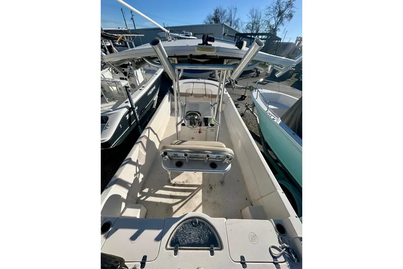 Slide: The Image of 2018 Carolina Skiff 238 DLV boat interior with console and seating, docked outdoors. - 4