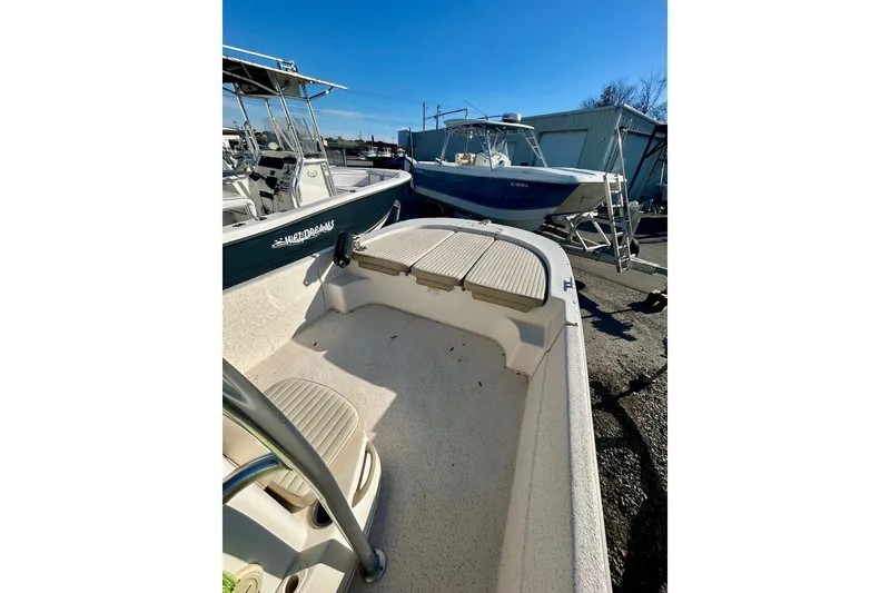 Slide: The Image of 2018 Carolina Skiff 238 DLV boat docked outdoors under clear blue sky. - 7
