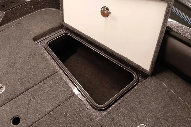 Slide: The Image of Open storage compartment in 2026 Ranger 2050MS Reata boat, featuring carpeted interior. - 15