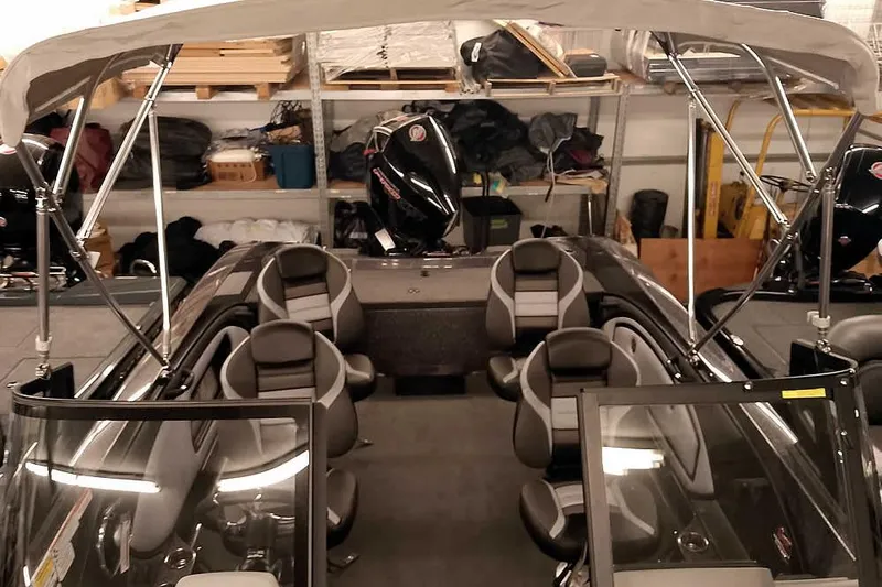 Slide: The Image of 2026 Ranger 2050MS Reata boat interior with seating and canopy in storage. - 22