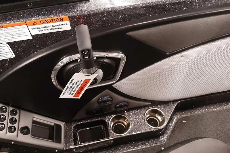 Slide: The Image of 2026 Ranger 2050MS Reata boat console with throttle, caution labels, and cup holders. - 31