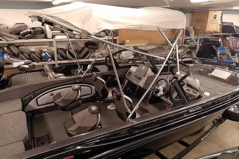 Slide: The Image of 2026 Ranger 2050MS Reata boat with canopy in storage, featuring sleek interior design. - 42