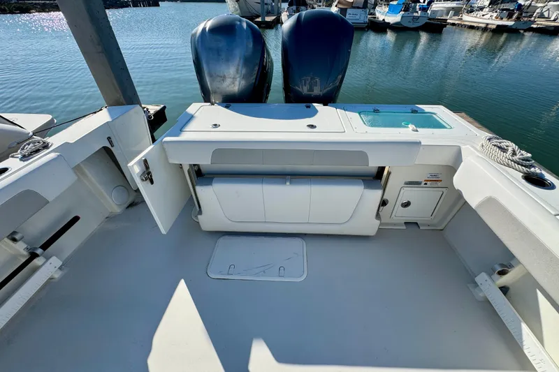 Slide: The Image of 2021 Parker 2820 XLD Sport Cabin boat interior with storage and twin engines. - 12