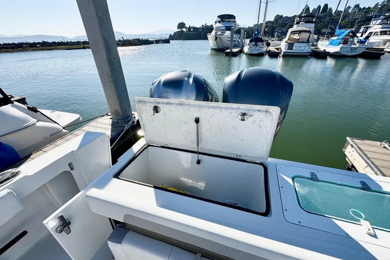 Slide: The Image of 2021 Parker 2820 XLD Sport Cabin boat with open storage compartment at marina. - 13