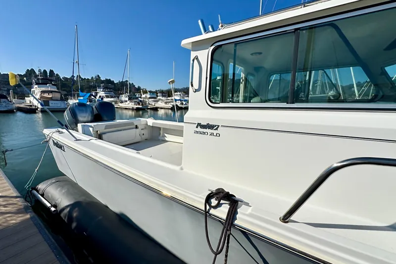 Slide: The Image of 2021 Parker 2820 XLD Sport Cabin boat docked in a marina under clear blue skies. - 4