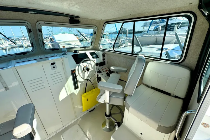 Slide: The Image of 2021 Parker 2820 XLD Sport Cabin interior with helm, seating, and marina view. - 7