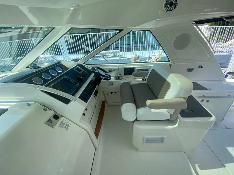 Slide: The Image of Helm of 2012 Sea Ray 450 Sundancer yacht with modern controls and seating. - 12
