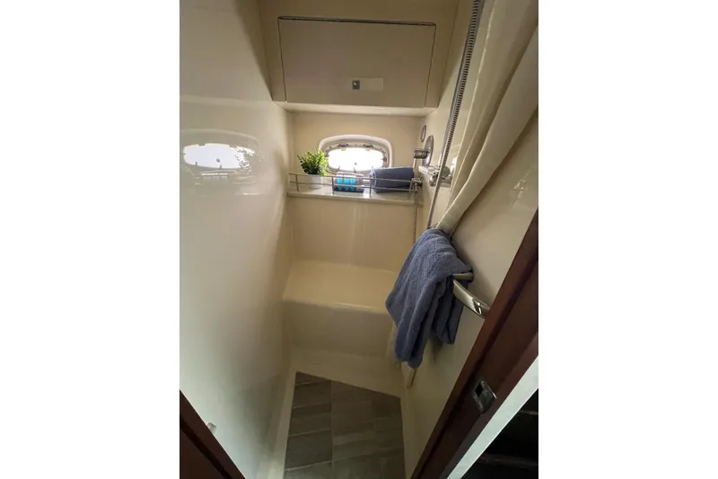 Slide: The Image of Compact bathroom in 2012 Sea Ray 450 Sundancer yacht with towel and window. - 21