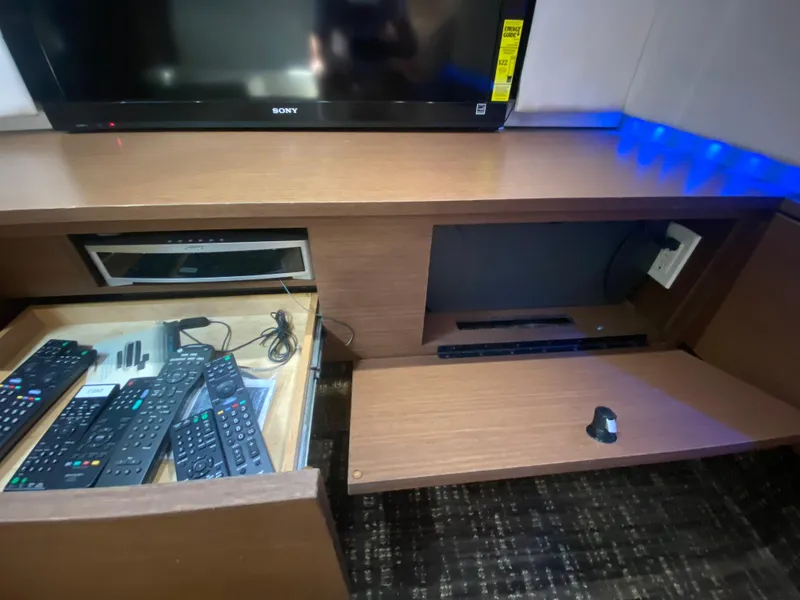 Slide: The Image of Entertainment system with remotes and TV on a 2012 Sea Ray 450 Sundancer yacht. - 26