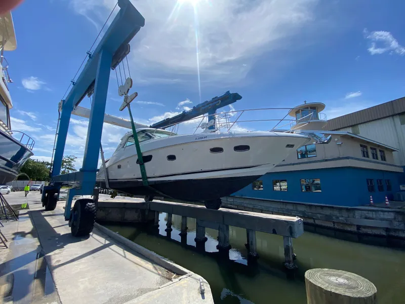 Slide: The Image of 2012 Sea Ray 450 Sundancer yacht lifted by crane at marina. - 40
