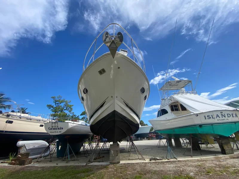 Slide: The Image of 2012 Sea Ray 450 Sundancer yacht on dry dock, flanked by other boats under a clear blue sky. - 43