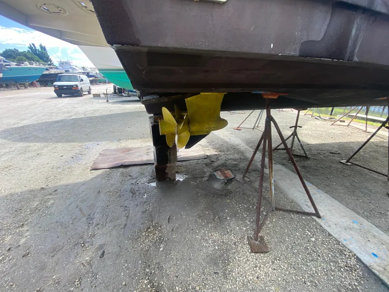 Slide: The Image of 2012 Sea Ray 450 Sundancer on dry dock, showing propeller and hull. - 47