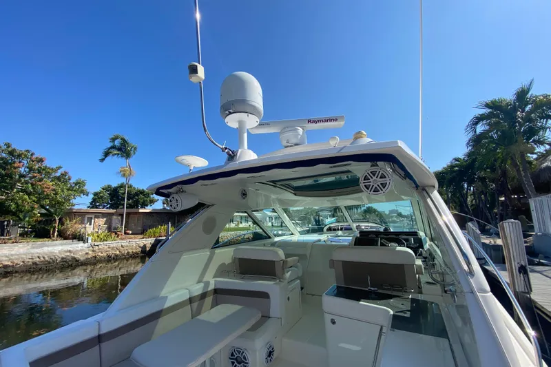 Slide: The Image of 2012 Sea Ray 450 Sundancer yacht docked, featuring spacious seating and advanced navigation equipment. - 51