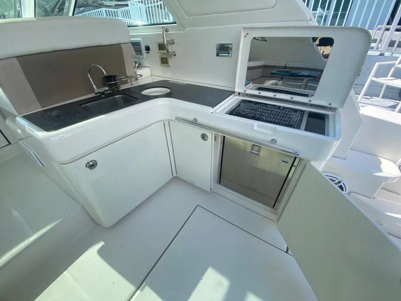 Slide: The Image of 2012 Sea Ray 450 Sundancer yacht kitchen area with sink, grill, and storage. - 8