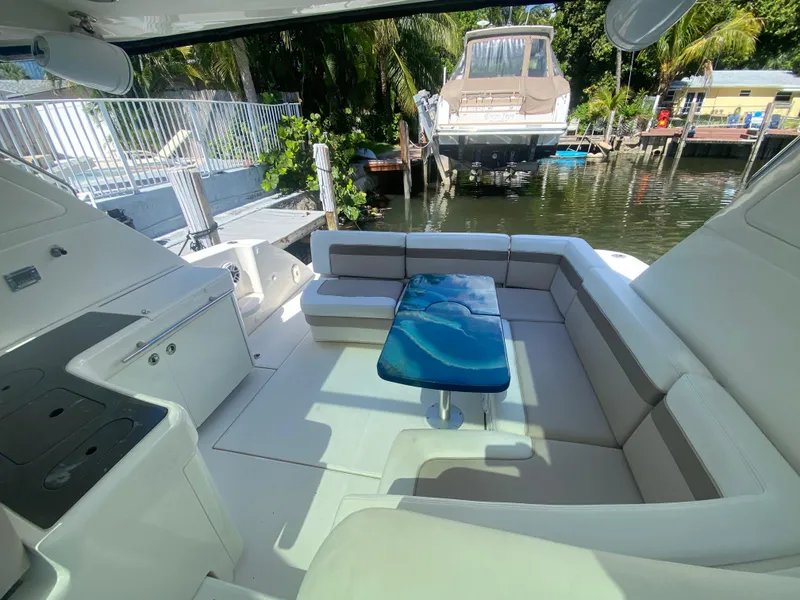 Slide: The Image of Luxurious 2012 Sea Ray 450 Sundancer yacht interior with sleek seating and stylish blue table. - 9