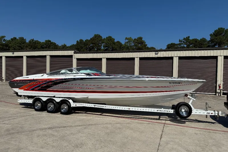The Image of 2007 Formula 353 FASTech speedboat on trailer, parked near storage units. - 0