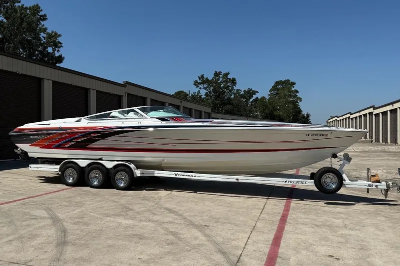 Slide: The Image of 2007 Formula 353 FASTech speedboat on trailer, parked outdoors, showcasing sleek design and vibrant graphics. - 4