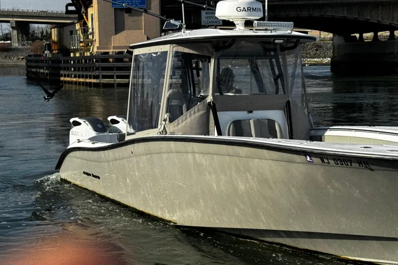 Slide: The Image of 2024 Cape Horn 32 T boat on water near a bridge, featuring Suzuki engines. - 2