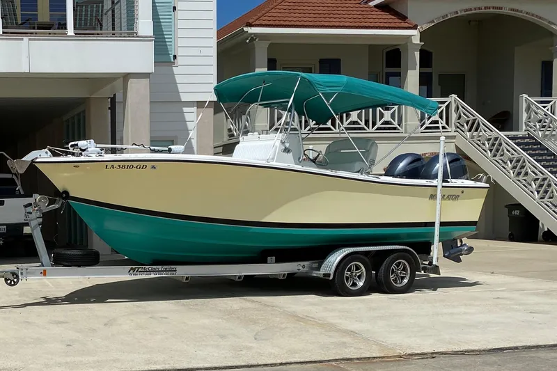 The Image of 2002 Regulator 23 Classic boat on trailer, parked near a house with teal canopy. - 1