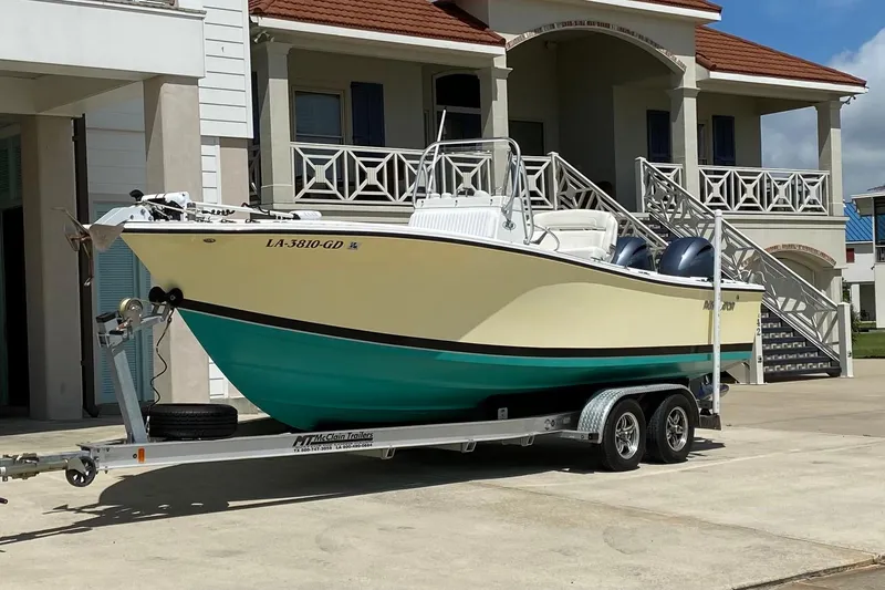 Slide: The Image of 2002 Regulator 23 Classic boat on trailer, parked near a house with stairs. - 5