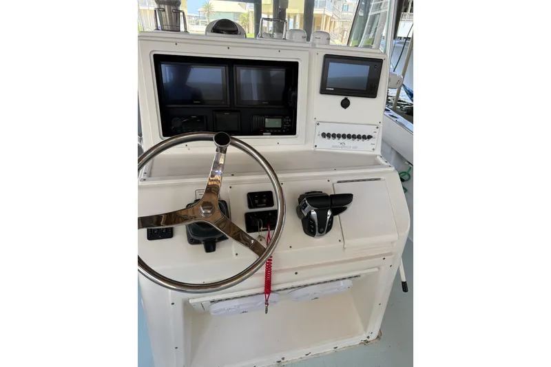 Slide: The Image of 2002 Regulator 23 Classic boat dashboard with steering wheel and control panel. - 9